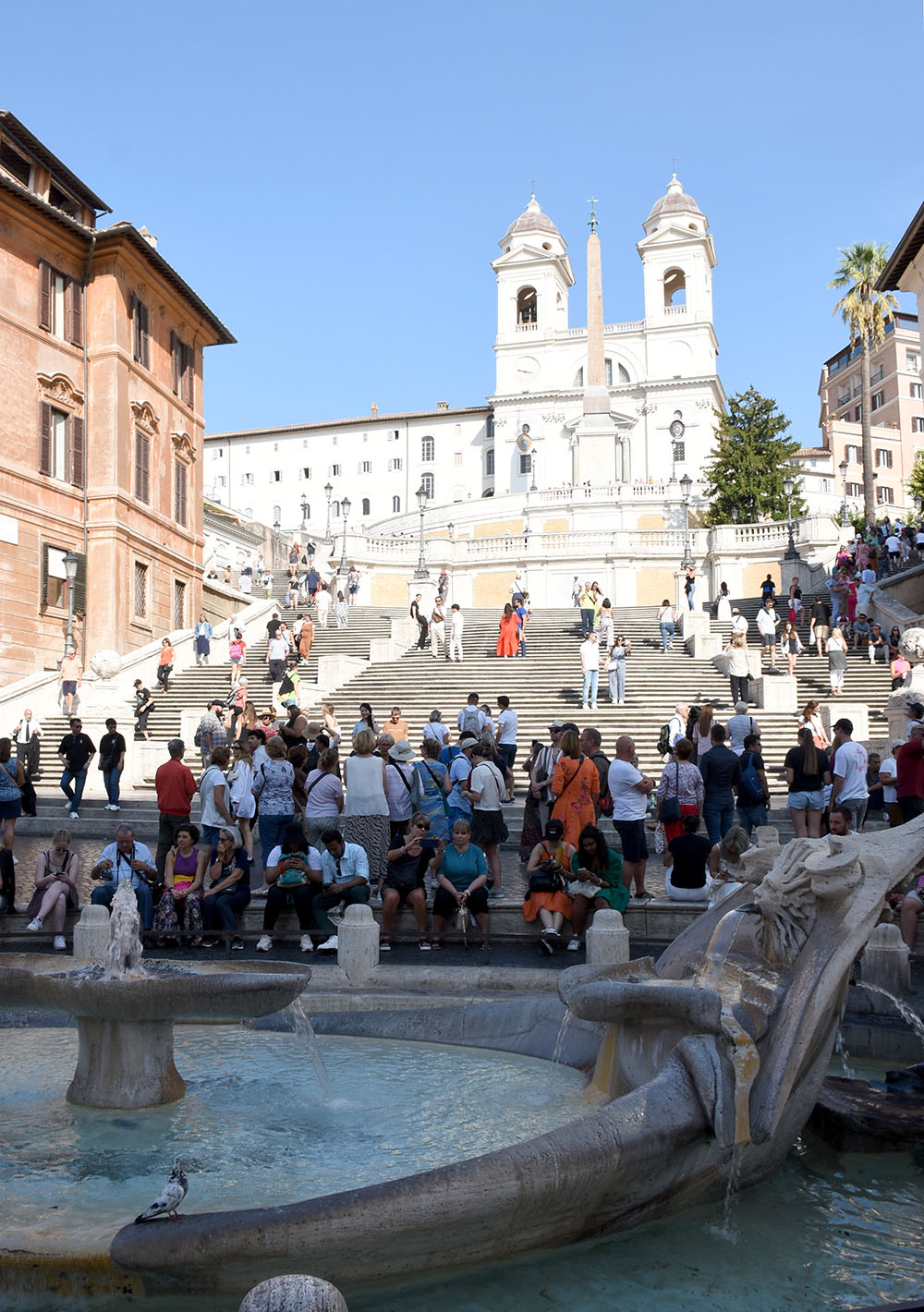 Lively scene in front of the Barcaccia Fountain and at the Spanish Steps in Rome.