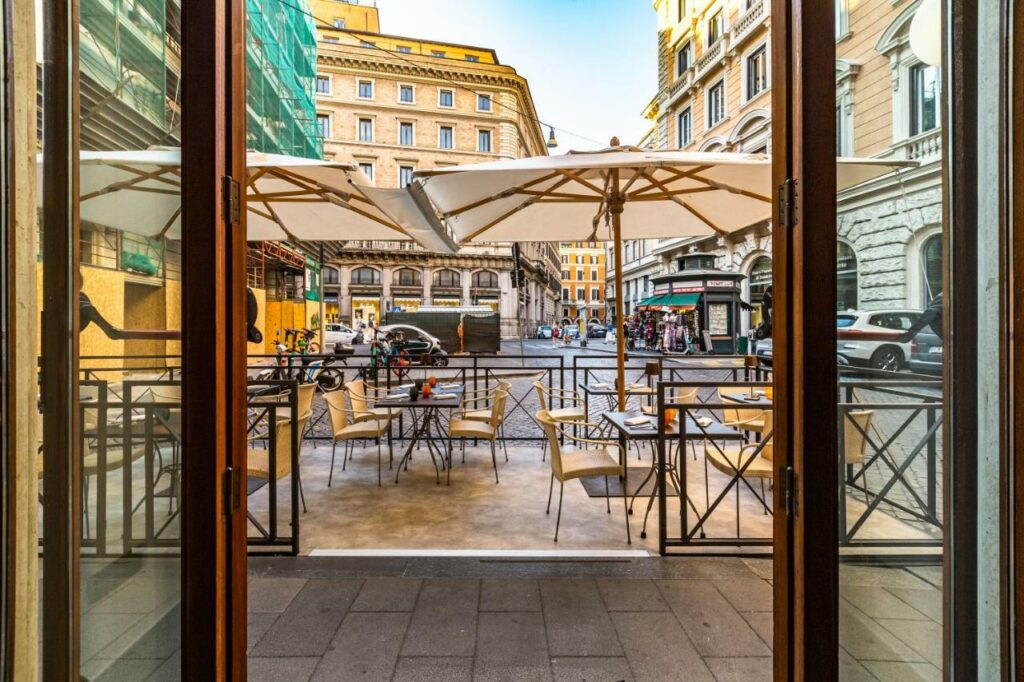 Set tables with umbrellas in front of the Hotel Delle Nazioni.