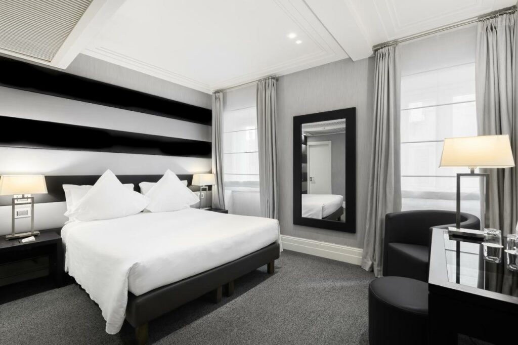 A modernly furnished hotel room with a double bed.