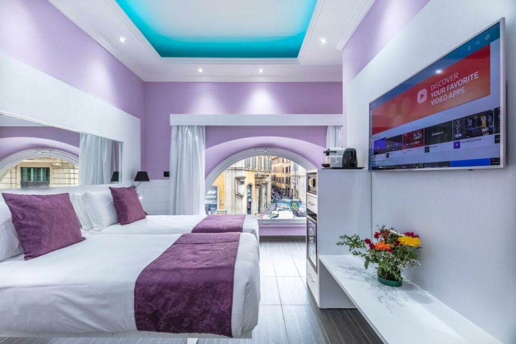 Pink colors of hotel room with big round window and tv