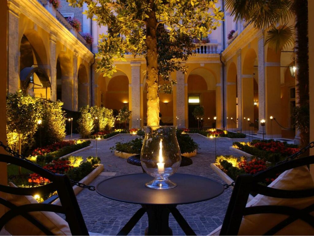 Illuminated table and chairs in a courtyard at night, creating a cozy atmosphere.